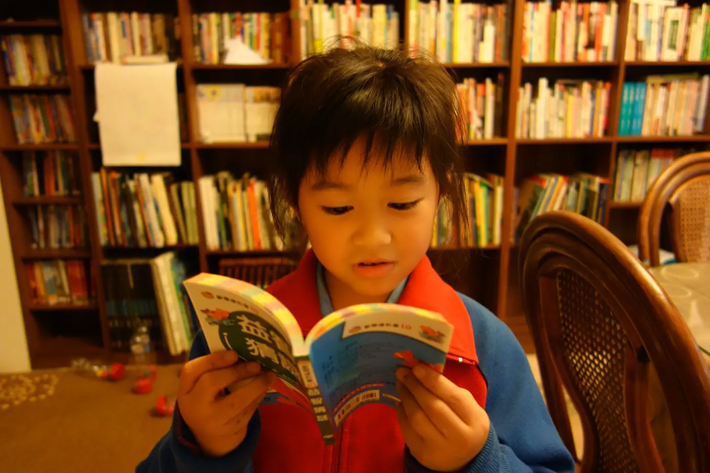 Niño leyendo un libro en una biblioteca